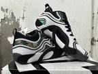 Pair of white and black sneakers displayed to show the side panels and outsole