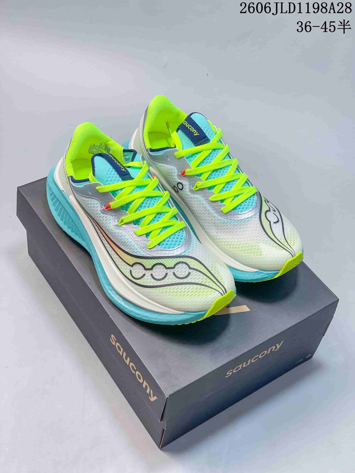 Pair of white and aqua Saucony Endorphin Speed 5 running shoes with bright yellow-green laces on a shoe box