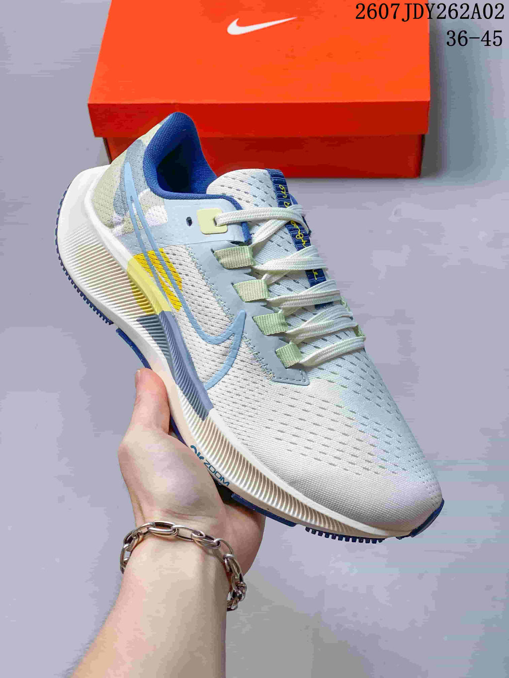 Close side view of a Nike Pegasus 38 shoe showing its perforated upper and colored overlays.