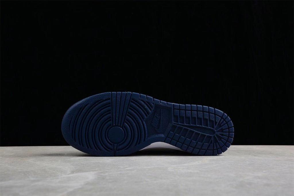 Bottom view showing the navy rubber outsole with circular forefoot and grid-pattern traction.