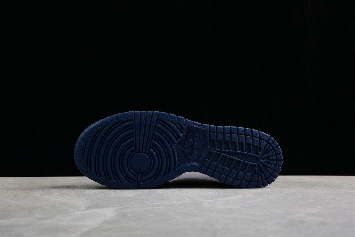 Bottom view showing the navy rubber outsole with circular forefoot and grid-pattern traction.