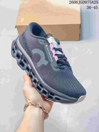 Angled side view of a charcoal On Cloudmonster 3 running shoe with its sculpted sole.