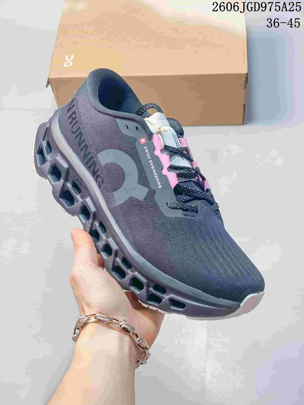Angled side view of a charcoal On Cloudmonster 3 running shoe with its sculpted sole.