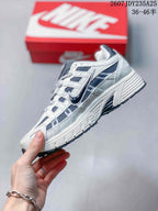 Side profile of a white and dark navy Nike P-6000 sneaker showing the layered upper and raised midsole.