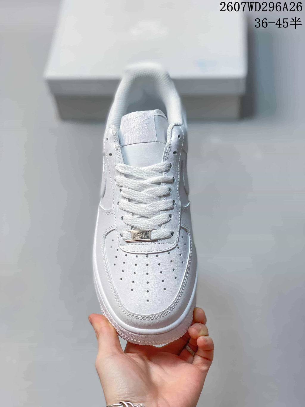 Top view of a white sneaker showing the perforated toe box, white laces and AF1 lace tag.