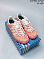 Pair of pink and white adidas Samba ADV sneakers displayed on a blue shoebox.