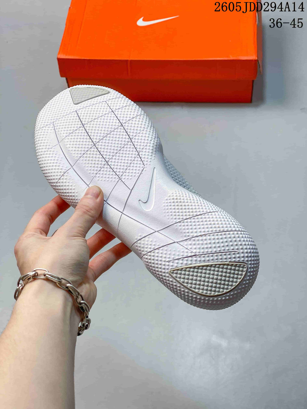 Underside view of the white Nike sneaker outsole showing segmented flex grooves and textured traction areas.