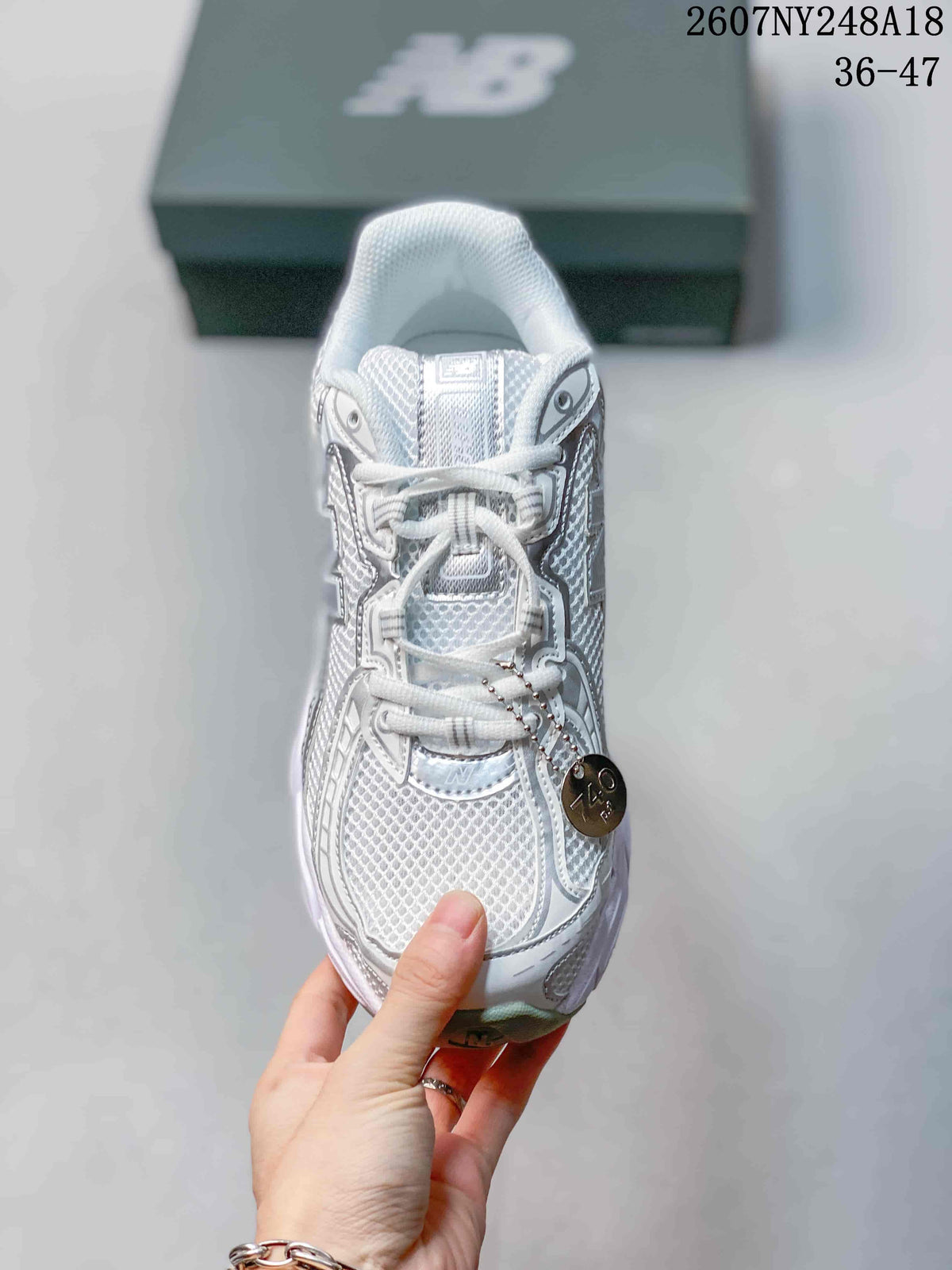 Top-down view of the lace-up sneaker showing the mesh-style toe area, tongue, and decorative hanging tag.