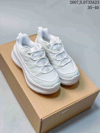 Pair of white low-top sneakers displayed on a cardboard shoe box, with the source size range and style reference visible above.