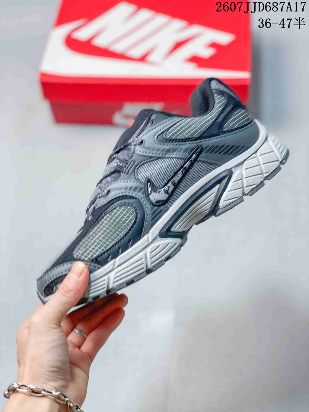 Side view of a gray Nike V5 RNR sneaker showing layered overlays, mesh-style panels, and the sculpted midsole.
