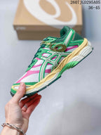 Side profile showing the green and pink mesh-style upper, layered overlays, cream midsole and contrasting outsole.