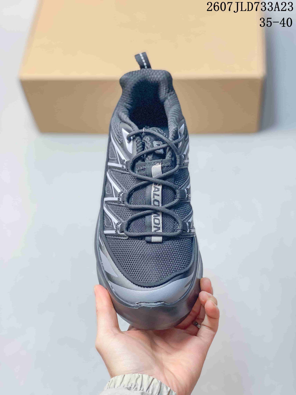 Top view of the sneaker showing the mesh-like vamp, lace system, layered panels and visible Salomon branding.