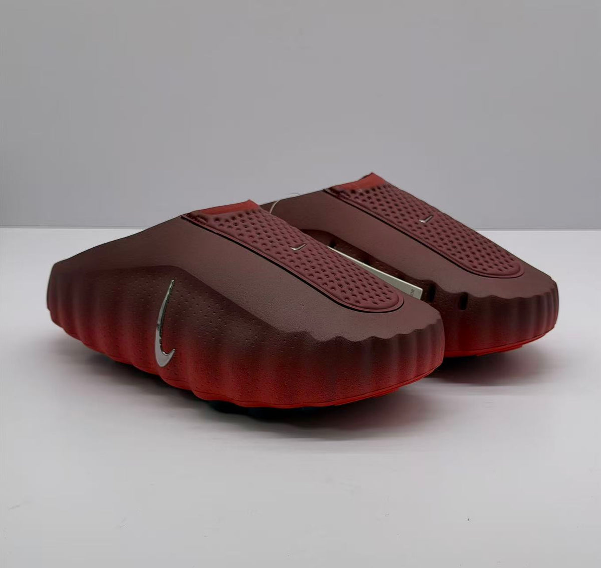 Pair of dark red slip-on sneakers shown from a three-quarter front angle.