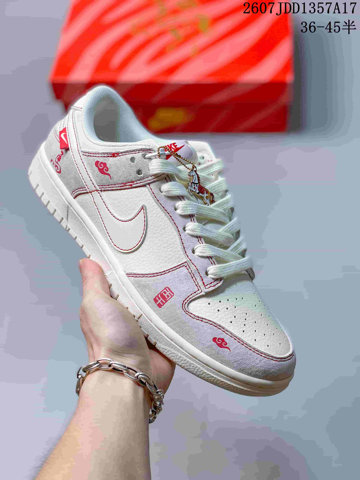 White and light grey low-top sneaker with red stitching, decorative graphics and white laces.