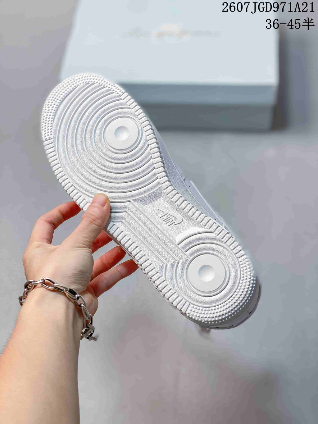 Close view of the white sneaker outsole showing circular traction rings and a textured perimeter.