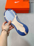 Close-up of the textured blue and light-colored outsole of the running shoe.