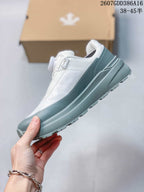 Side profile of the white and gray low-top sneaker showing its layered upper and thick midsole.