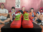 Front view of red basketball shoes with bright green laces and textured uppers.