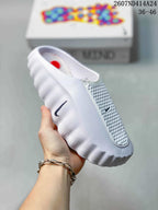 White Nike Mind 001 slip-on slide with contrasting Nike branding and a perforated forefoot panel.