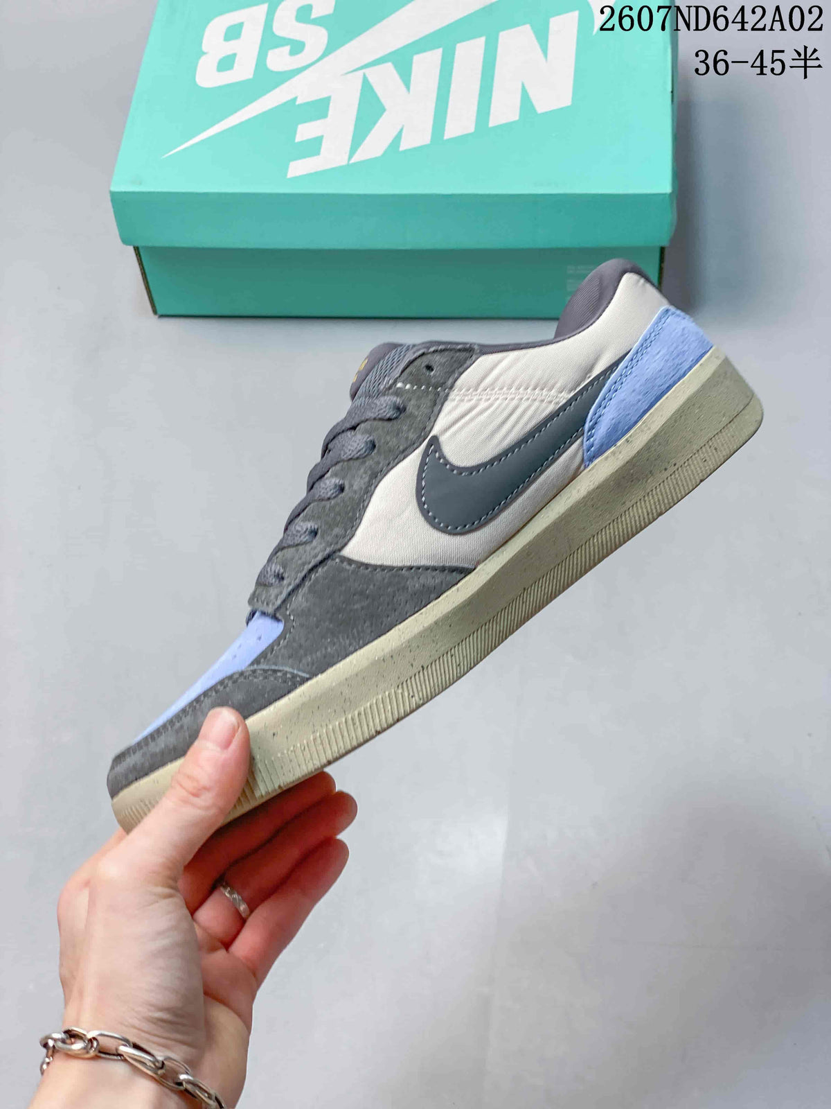 Side profile showing gray overlays, pale neutral panels, a blue heel accent, and a speckled sole