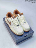Pair of cream and white Nike Air Force 1 low-top sneakers with brown accents displayed on a shoebox.