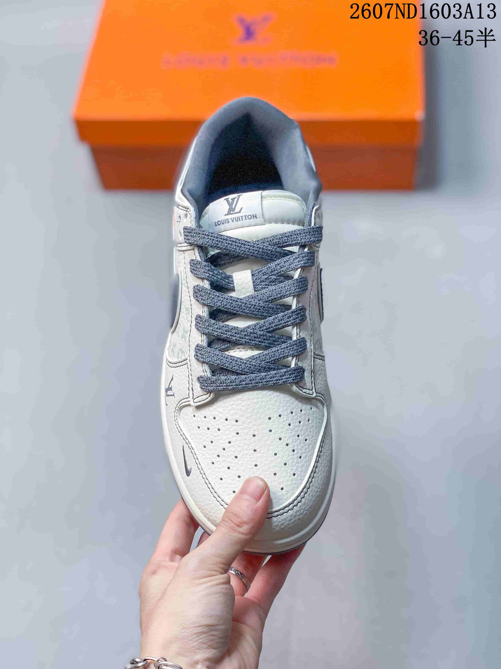 Top view of a white and grey low-top sneaker with dark grey laces, perforated toe box, and printed panel detailing.