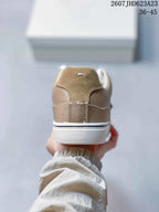 Rear view showing the taupe heel panels, stitching, and layered white sole.