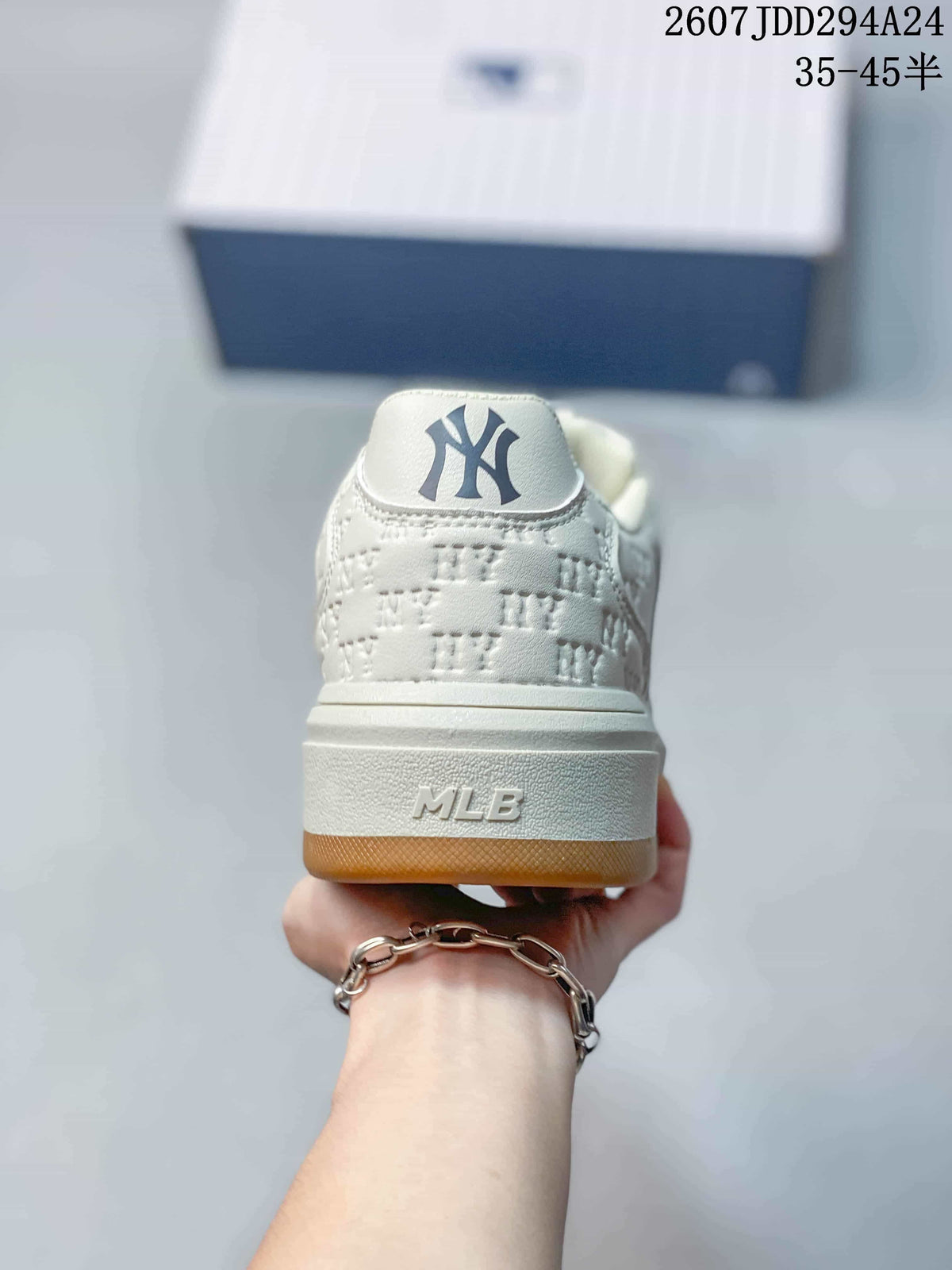 Rear view of the white sneaker showing the New York logo on the heel tab, MLB branding on the midsole, and gum-colored outsole.
