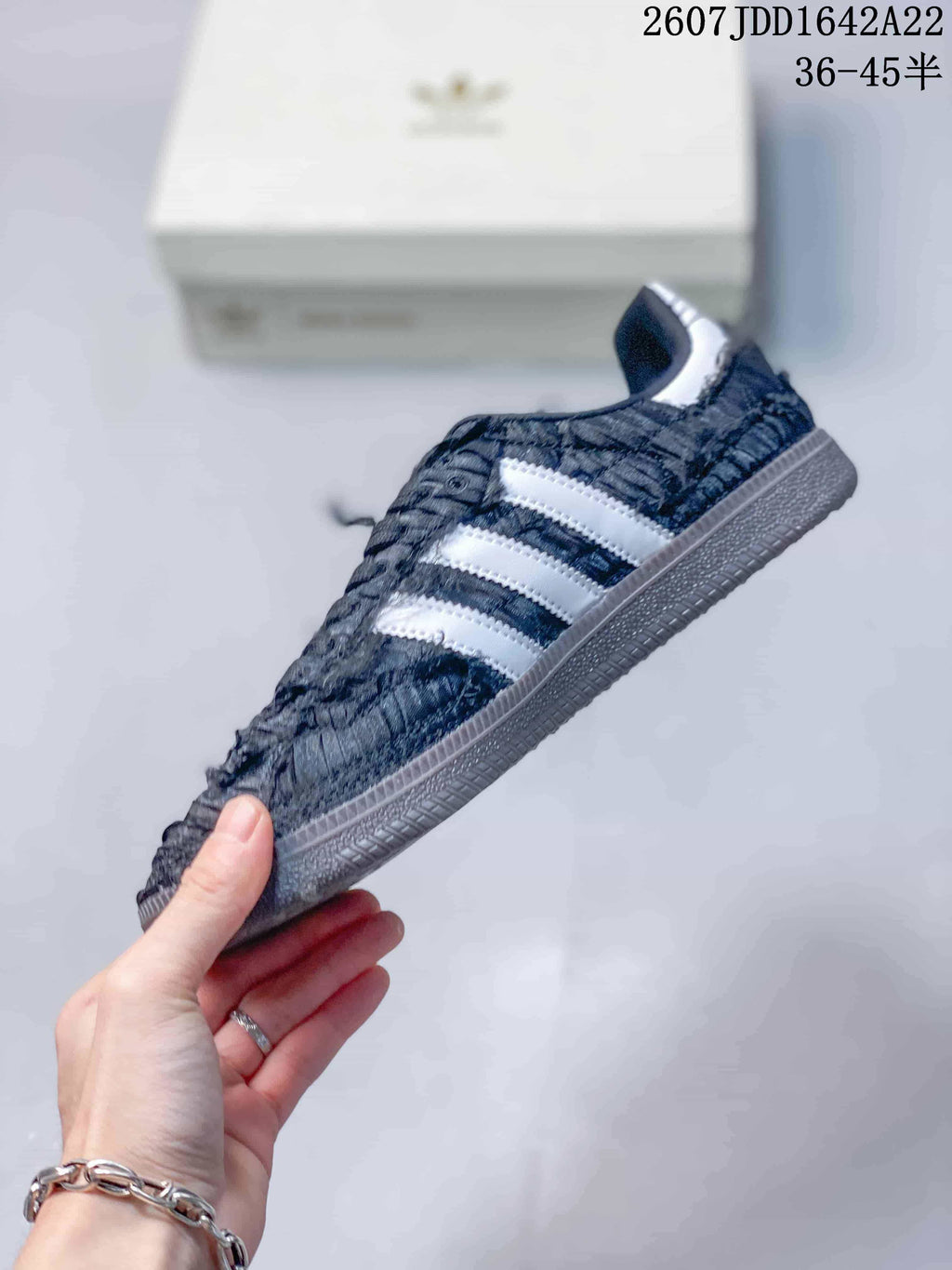 Side profile of the low-top sneaker with white adidas stripes and layered textured upper detailing.