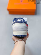 Rear view of the sneaker showing the navy heel panel, white layered heel construction, and branded heel details.