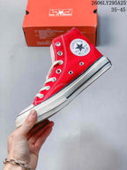 Side view of the red high-top sneaker showing the ankle patch, metal eyelets, contrast stitching, and rubber sole.