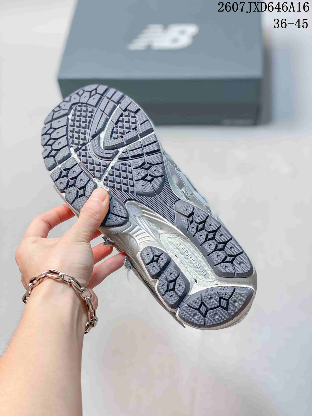 Bottom view of a New Balance 1906A sneaker showing the segmented patterned outsole.