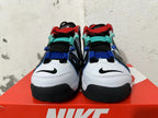 Front view of white sneakers with black detailing and red, teal, and blue accents.