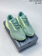 Pair of green and lime Nike ACG Ultrafly Trail sneakers displayed on a shoe box.