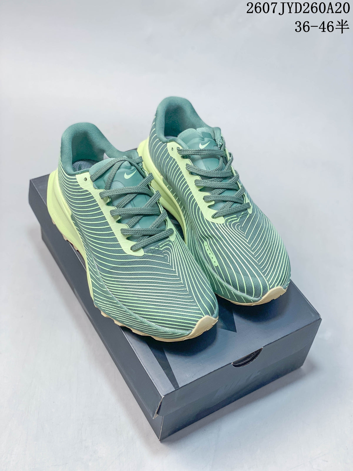 Pair of green and lime Nike ACG Ultrafly Trail sneakers displayed on a shoe box.