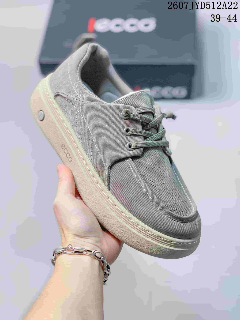 Angled side view of a gray ECCO lace-up sneaker showing the layered upper, laces, heel detail, and outsole.