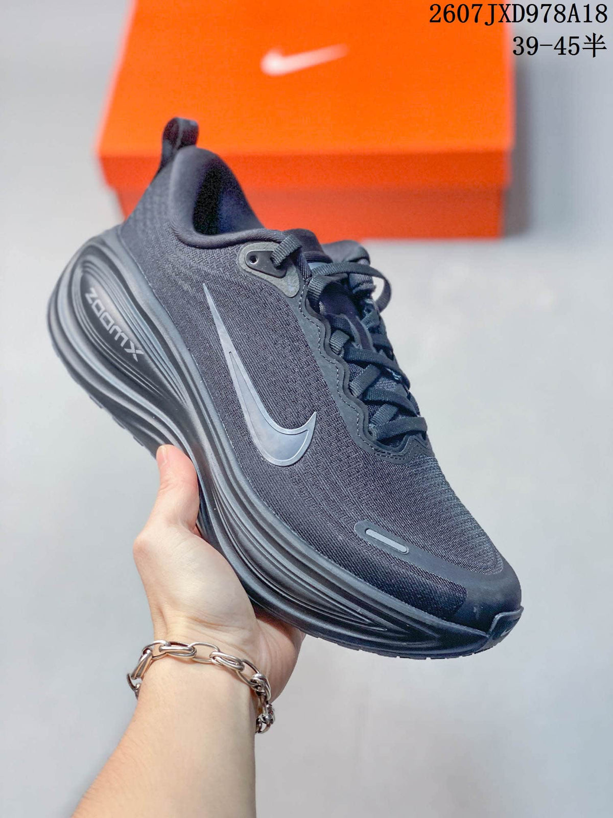 Black Nike Vomero Plus running shoe with a gray swoosh and matching dark outsole.