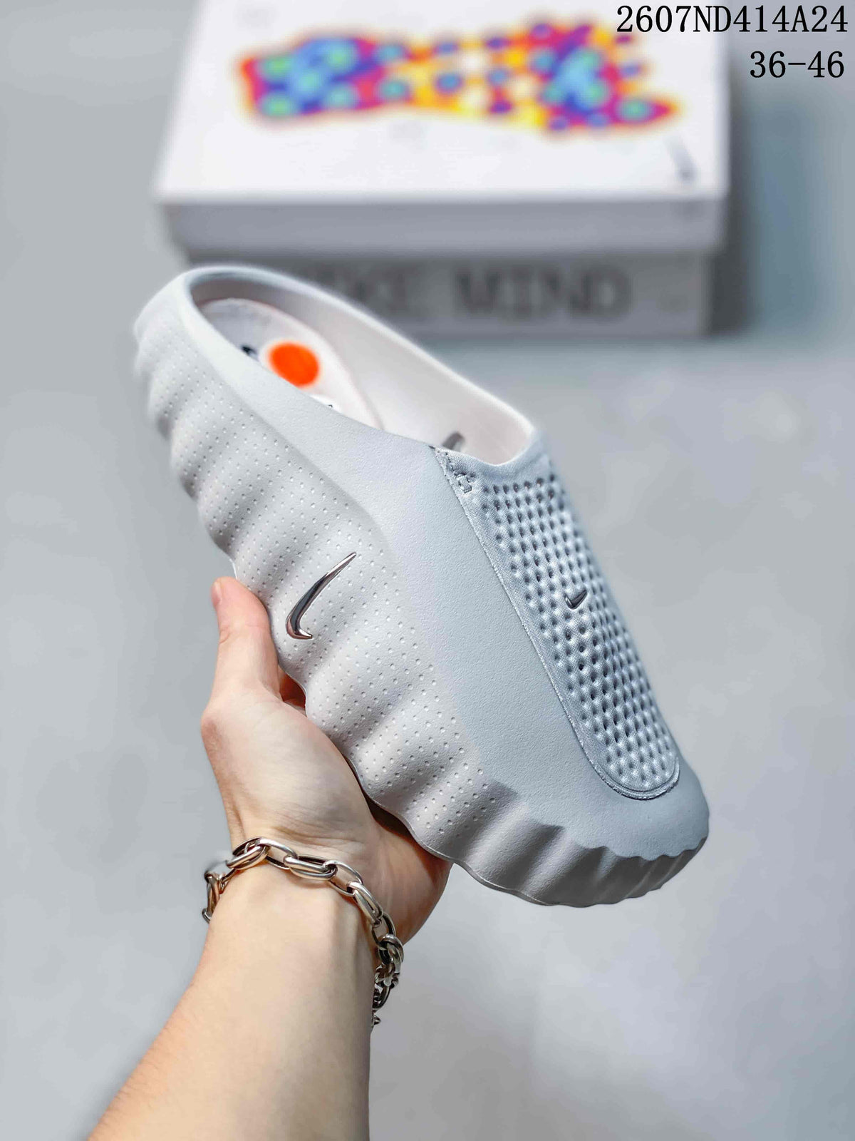 Angled side view showing the slip-on opening, perforated upper, side Swoosh, and sculpted outsole.