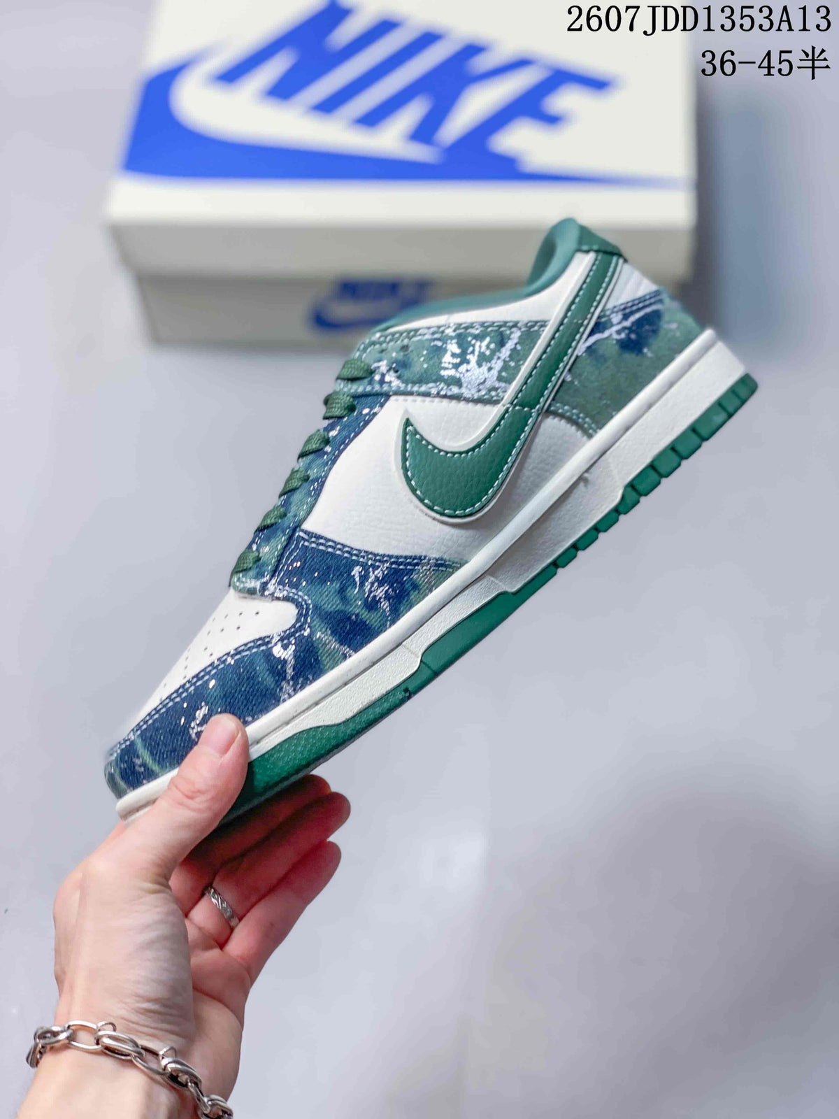 Side profile showing the white base, green Swoosh detail, blue patterned overlays and stitched construction.