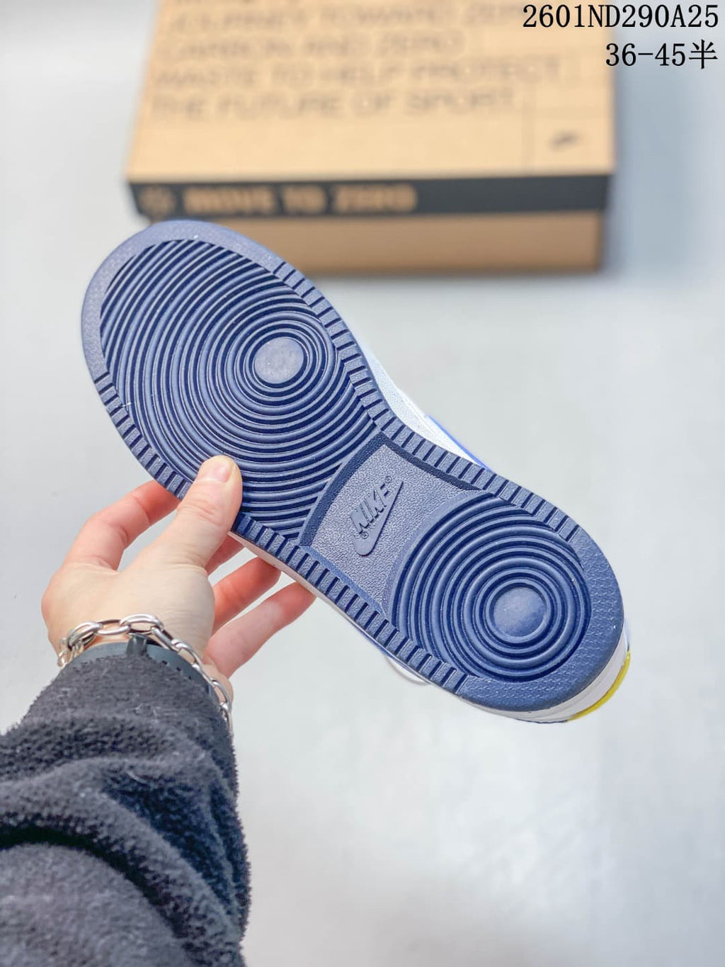 Close view of the sneaker outsole showing a blue circular traction pattern and textured perimeter.