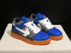 Front three-quarter view showing the blue toe boxes, white laces, grey panels, and large side arrow details.