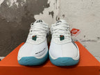 Front view of white Nike basketball shoes with perforated panels and blue outsole edges