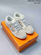 Pair of cream-white low-top sneakers with beige patterned panels and light contrasting laces.