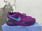Side view of a purple Nike basketball shoe with a turquoise Swoosh and speckled dark midsole
