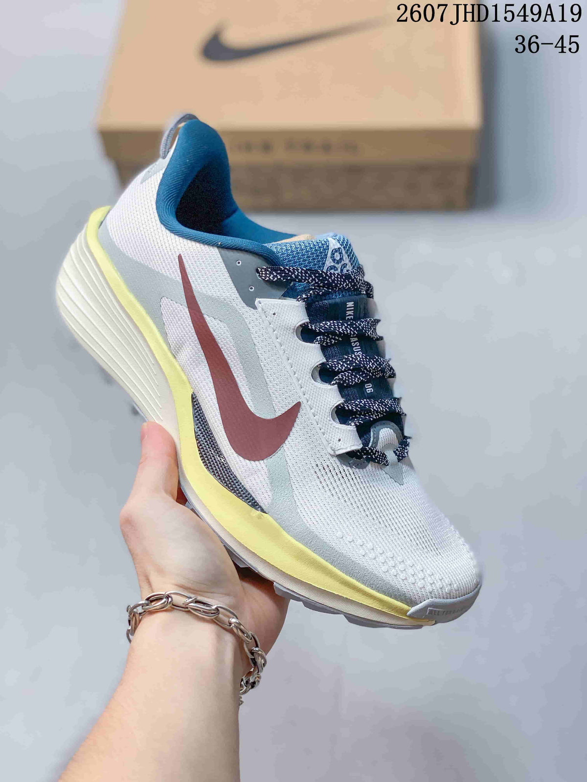 Light gray Nike Zoom Fly 5 sneaker with a burgundy Swoosh, blue collar, and yellow outsole accents.