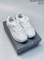 White EA7 low-top sneakers with textured toe panels, white laces and a serrated outsole displayed on a branded box.