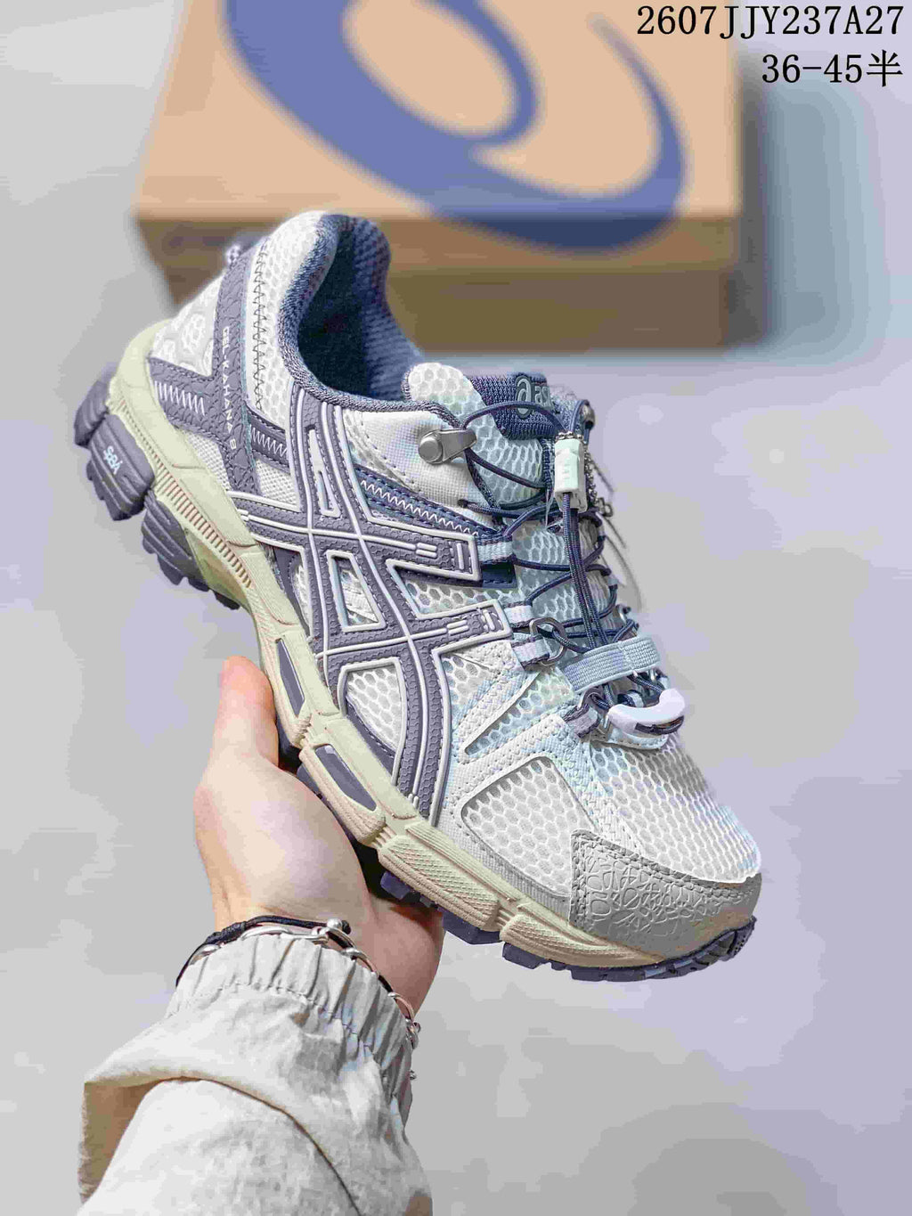 Three-quarter side view showing the white and gray upper, muted purple accents, and rugged outsole.