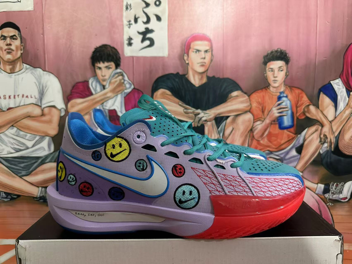 Side view of a Nike basketball sneaker showing the Swoosh, colorful smiley-face patches, teal upper, and red outsole.