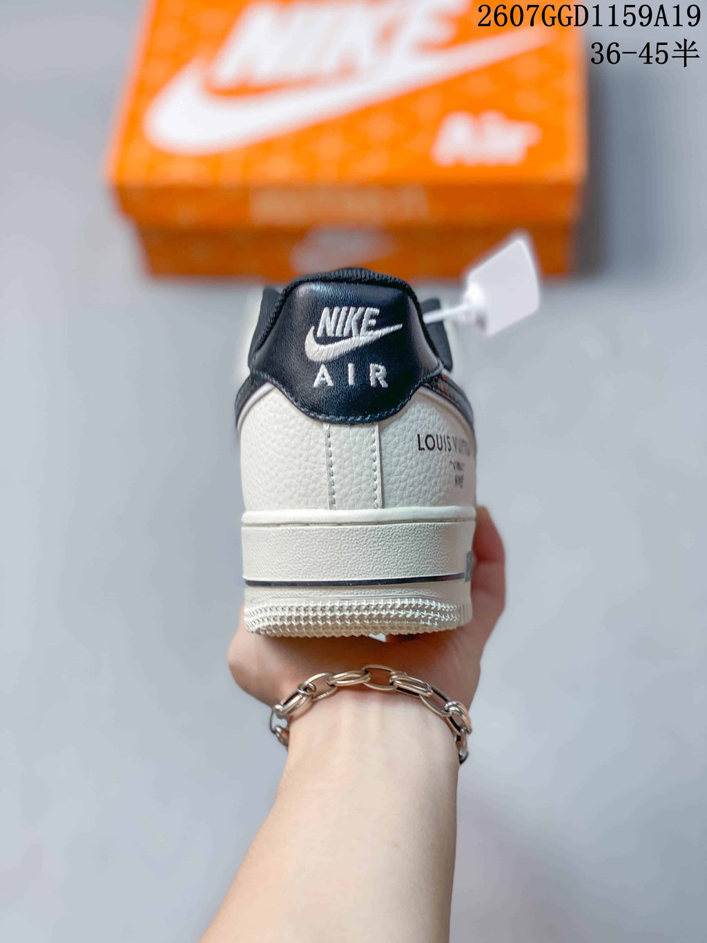 Rear view of a white sneaker showing a black padded collar, Nike Air branding, and decorative heel lettering.