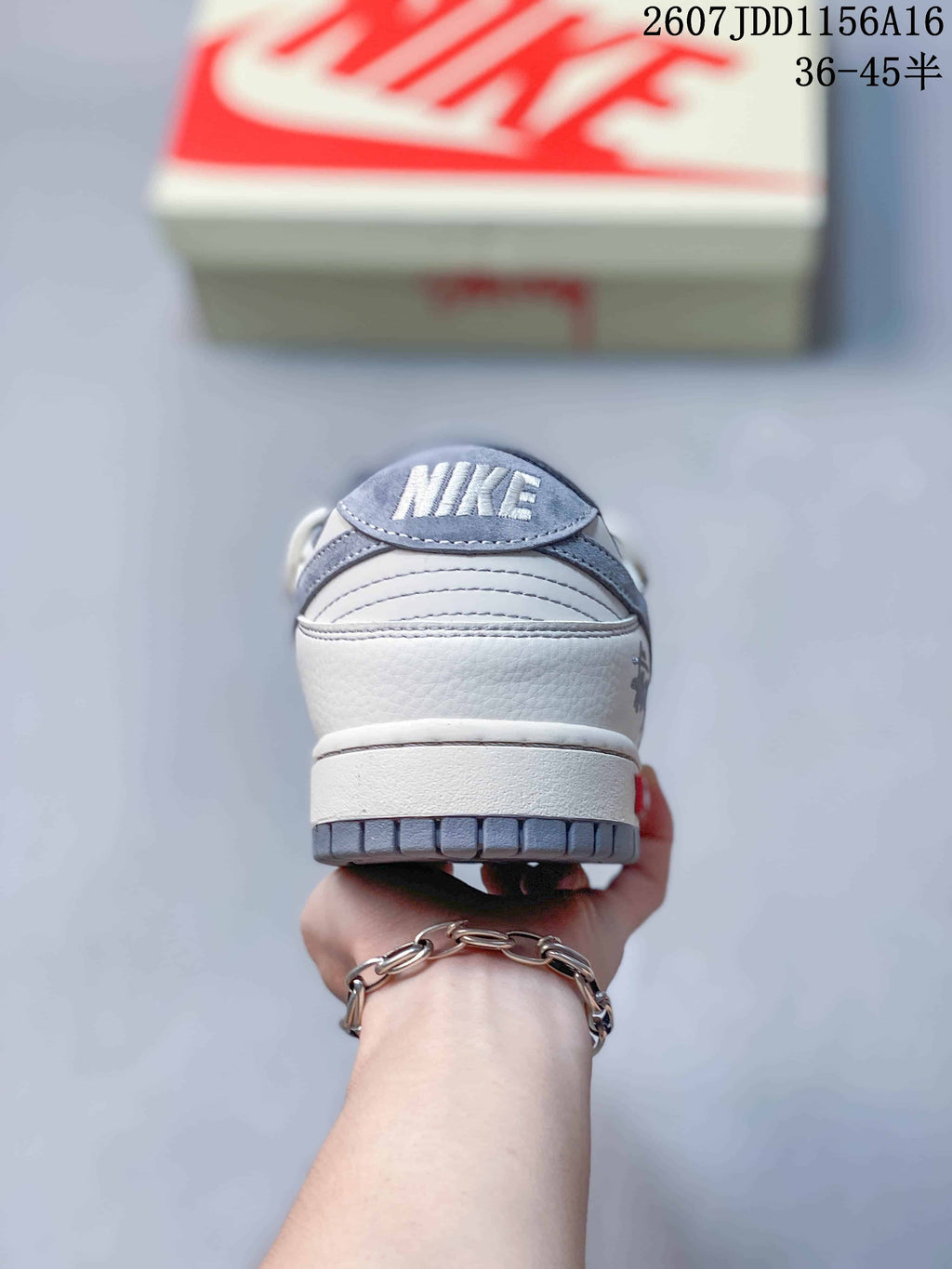Rear view of an off-white and gray low-top sneaker showing the padded heel and segmented gray outsole; image text shows style code 2607JDD1156A16 and size range 36–45.5.